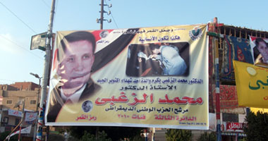 رئيس جامعة السويس يغازل ربات البيوت بلافتة يقبل فيها يد سيدة مسنة