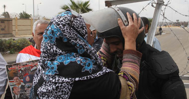 مواطنون يقبلوا "بيادات" الشرطة أثناء محاكمة مرسى فى قضية التخابر