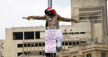 مواطن يقيد نفسه بعمود نور بالتحرير ويطالب برفع اليد عنه