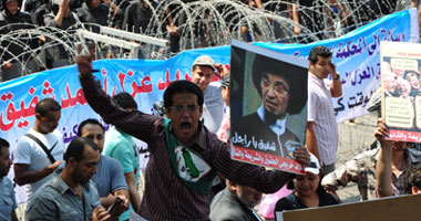 متظاهرو "الدستورية" يرفعون الأحذية اعتراضا على استمرار شفيق 