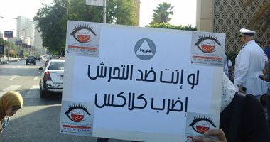 متظاهرة بدار الأوبرا ترفع لافتة "لو أنت ضد التحرش اضرب كلاكس"