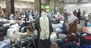 المعتمرون يبحثون عن حقائبهم فى مهبط مطار القاهرة 
