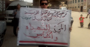  شاب فى بولاق الدكرور يتجول بلافتة ليذكر الناخبين بدم الشهداء